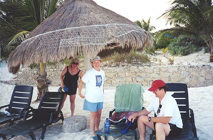 A 'palapa,' or thatched hut, offers shade on the white sand beach.